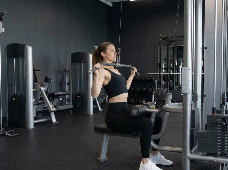 Woman doing a lat pulldown in a gym
