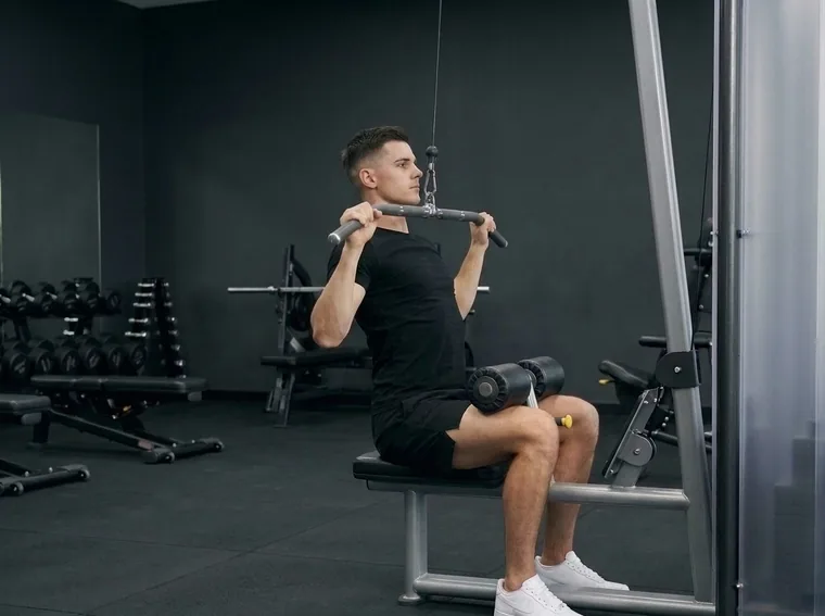 Man doing a lat pulldown in a gym